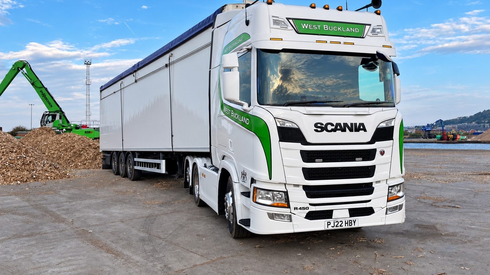 West Buckland Haulage Scania walking floor lorry beside a pile of wood chip at a port